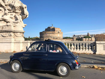 Vintage car in city against clear blue sky