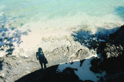 High angle view of people standing on rock in sea