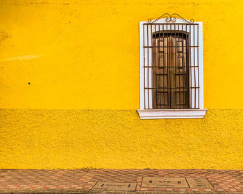 Yellow window on wall of building