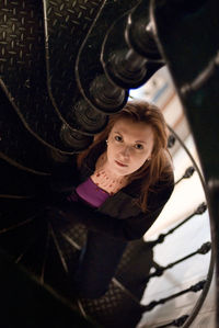 High angle portrait of woman standing on spiral staircase