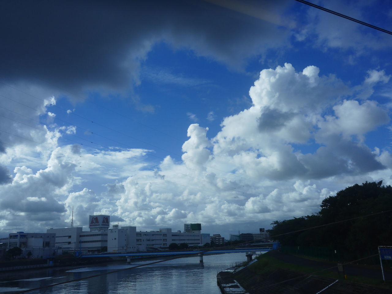 water, river, architecture, sky, built structure, transportation, building exterior, city, cloud - sky, bridge - man made structure, waterfront, cloud, day, outdoors, engineering, cloudy, canal, journey, city life, cloudscape, no people, urban skyline