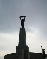 Low angle view of statue against cloudy sky