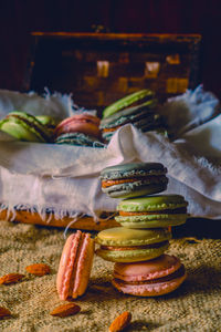 Stack of colorful macaroons with almonds on jute fabric