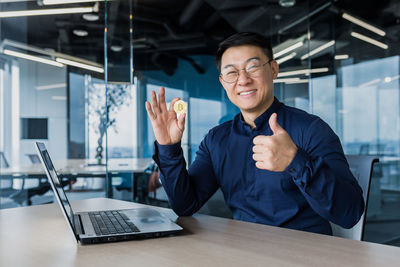 Portrait of businessman using laptop on table