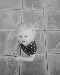 Portrait of girl standing by chalk drawing on floor