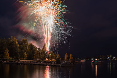 Firework display over river at night