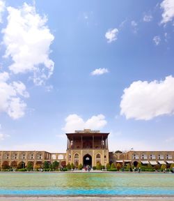 People in swimming pool against buildings