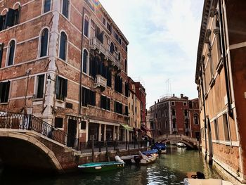 Canal amidst buildings against sky