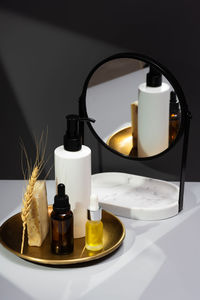 Creative still life with organic cosmetics. set of essential oils, handmade soap and mirror 