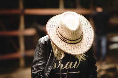 Woman wearing hat against wall