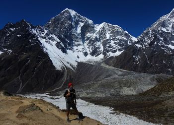 Man standing with snowcapped mountains during winter