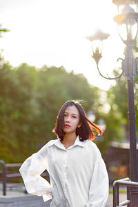 Portrait of young woman , short hair fly in wind. background summer green park