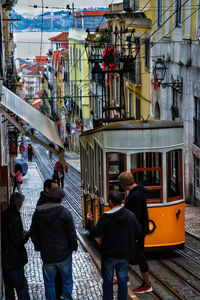 Rear view of people walking on street in city