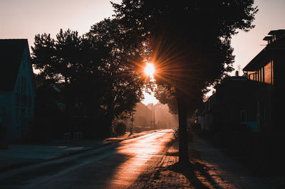 Illuminated street against sky during sunset