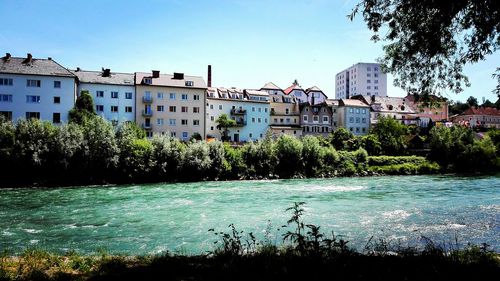 River by houses against clear sky