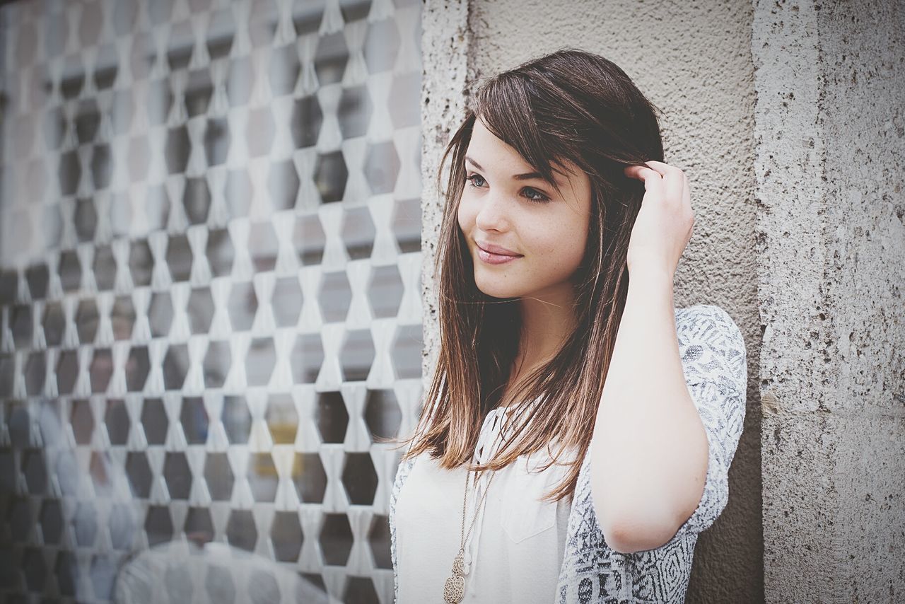 young adult, young women, portrait, person, looking at camera, front view, lifestyles, casual clothing, fashion, leisure activity, waist up, long hair, standing, smiling, necklace, dress, wall - building feature