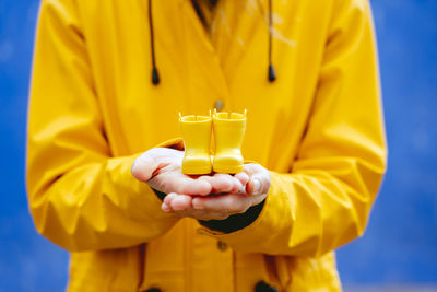 Midsection of woman holding toy boots