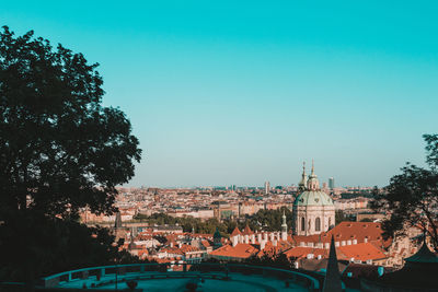 Buildings in city against clear blue sky