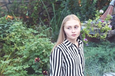 Portrait of woman standing against plants