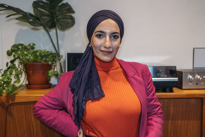 Portrait of young woman standing at home