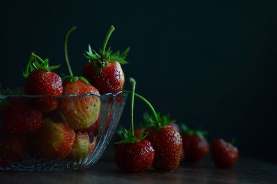 Close-up of strawberries on table against black background