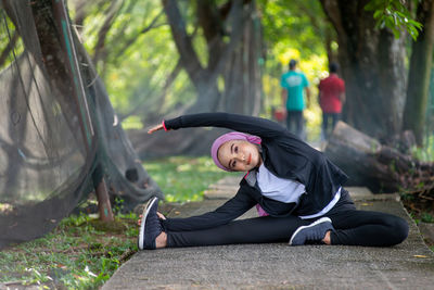 Portrait of young woman lying down on land