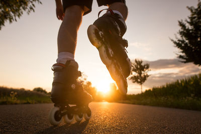 Low section of people riding motorcycle on road against sky