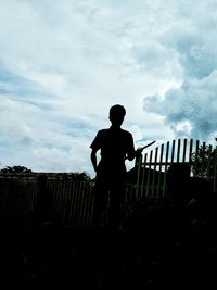 Low angle view of silhouette man standing against sky