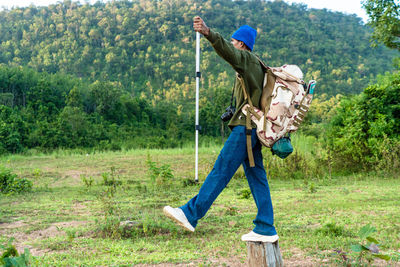 Full body man standing on field with forest and mountains traveling isolated