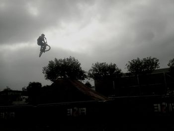 Silhouette of woman against cloudy sky