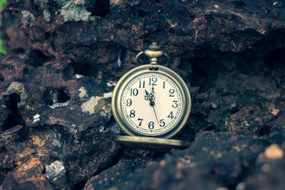 Close-up of pocket watch on rock