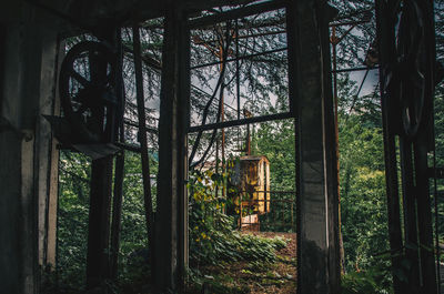 Old rusty overhead cable seen through window hanging in forest