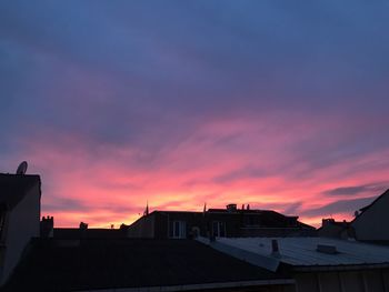 Silhouette buildings against sky at sunset