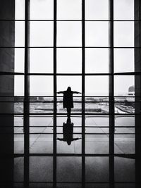 Rear view of silhouette people looking through window