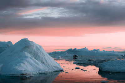 Scenic view of frozen lake against sky during sunset