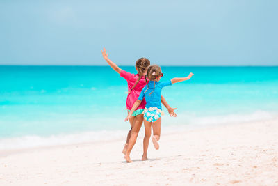 Full length of child on beach against sky