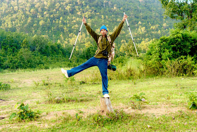 Full body man standing on field with forest and mountains traveling isolated