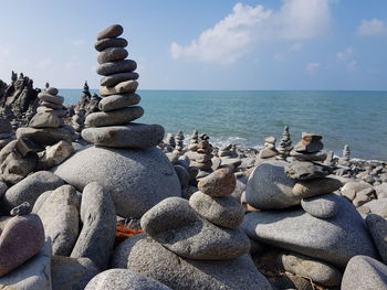 Stack of pebbles on beach against sky