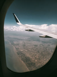 Aerial view of aircraft wing seen through airplane window