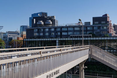 Bridge by buildings against sky in city