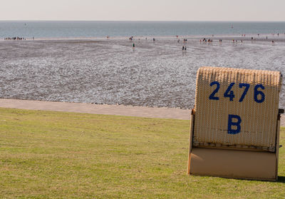 Hooded beach chair on shore against sky