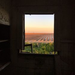 Scenic view of landscape against sky seen through window