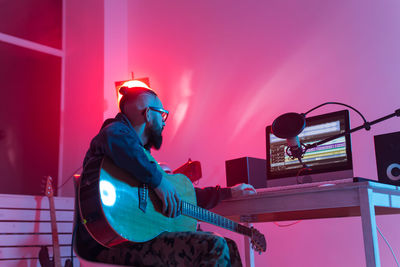 Young man playing guitar at music concert