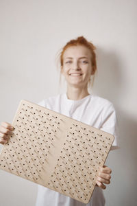 Portrait of smiling young woman against white background