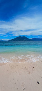 Scenic view of beach against blue sky