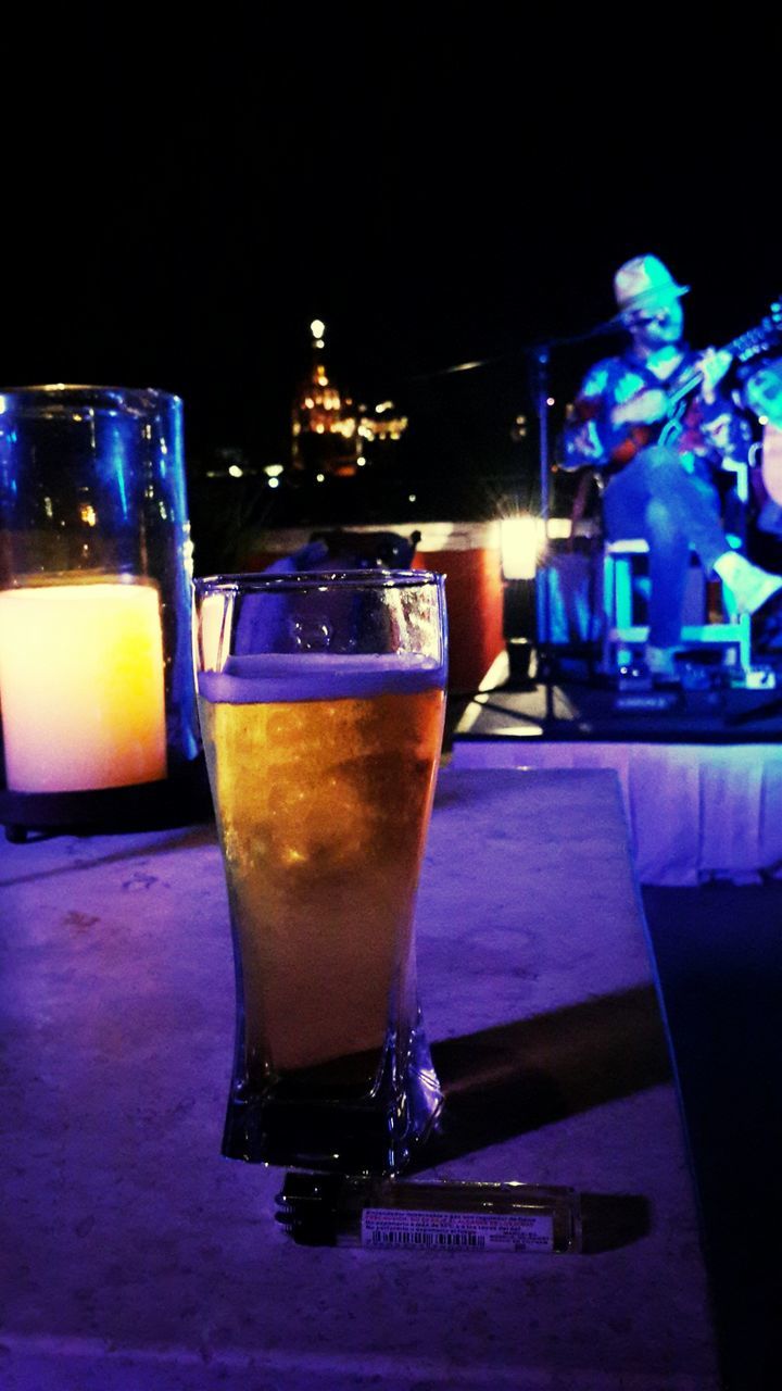 table, drink, illuminated, indoors, food and drink, still life, drinking glass, night, refreshment, close-up, focus on foreground, no people, alcohol, glass - material, restaurant, freshness, copy space, bottle, studio shot, selective focus