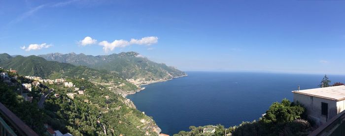 High angle view of sea and mountains against blue sky