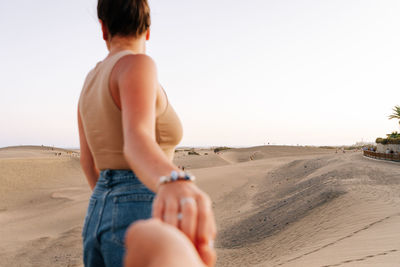 Rear view of shirtless man standing at beach