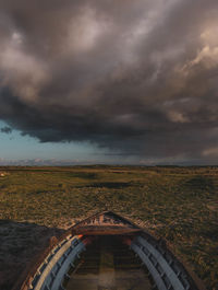 Scenic view of field against storm clouds