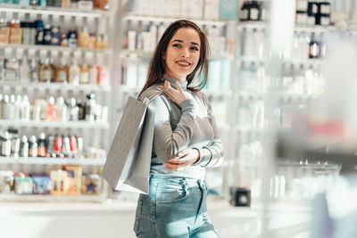 Portrait of smiling young woman standing in store